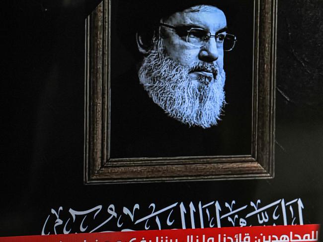 The late Hezbollah leader Hassan Nasrallah with a black stripe for mourning is displayed on a television set airing a broadcast from the private Lebanese station NBN in Beirut. Picture: AFP