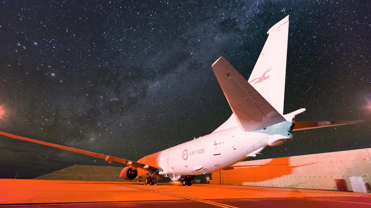 The spectacular Milky Way dominates the night sky as a No. 11 Squadron P-8A Poseidon sits on the hardstand at RAAF Base Learmonth.