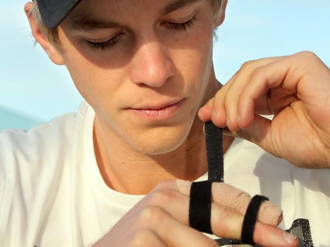 Tim Paine strapping the finger that almost ended his Test career.