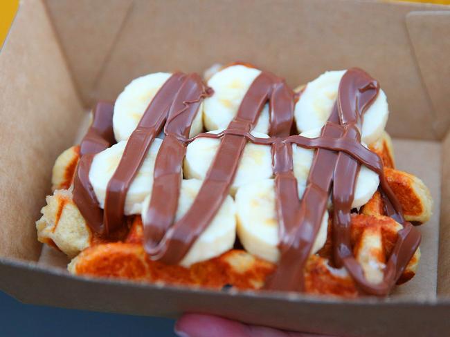 Waffles topped with bananas and coated with chocolate.