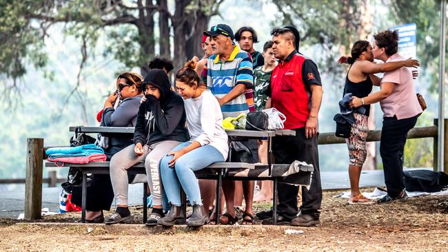 Family watches on as the boy’s body is loaded into a van. Picture: Monique Harmer