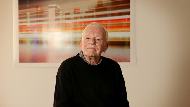 John Buckley, pictured at home in Melbourne in front of photos by David Stephenson, is selling off a big collection of his art collection.