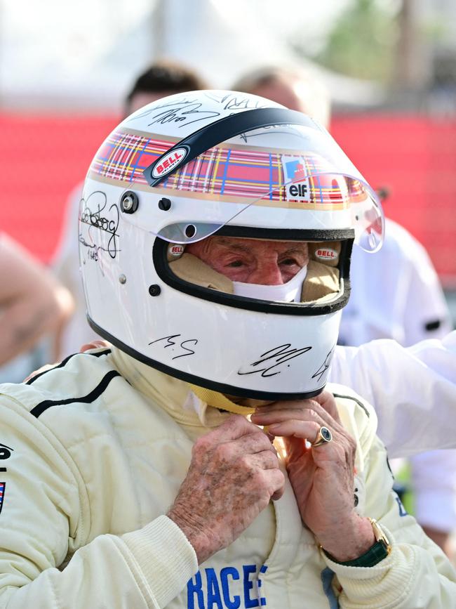 Former British Formula One racing driver Jackie Stewart takes off his helmet after her performed an exhibition lap ahead of the Bahrain Formula One Grand Prix. (Photo by Giuseppe CACACE / AFP)