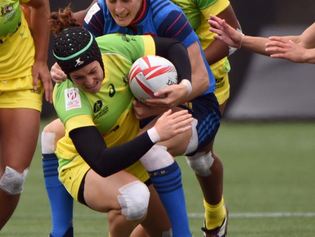 Australia (yellow) vies with France (blue) on the first day of the HSBC World Rugby Women's Sevens Series in Langford, BC, Canada on April 16, 2016. / AFP PHOTO / Don MacKinnon