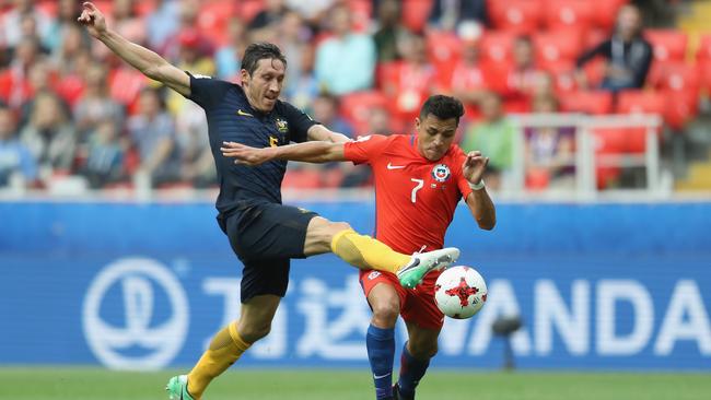 Mark Milligan steps in to stop Chile superstar Alexis Sanchez.