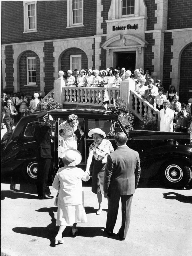 The Queen is greeted by a woman curtsying and chairman Rex Schiller as she arrives at Kaiser Stuhl winery, Nuriootpa.