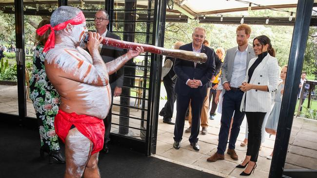 The royal couple are led into the restaurant by didgeridoo performer Russell Dawson. Picture: Getty