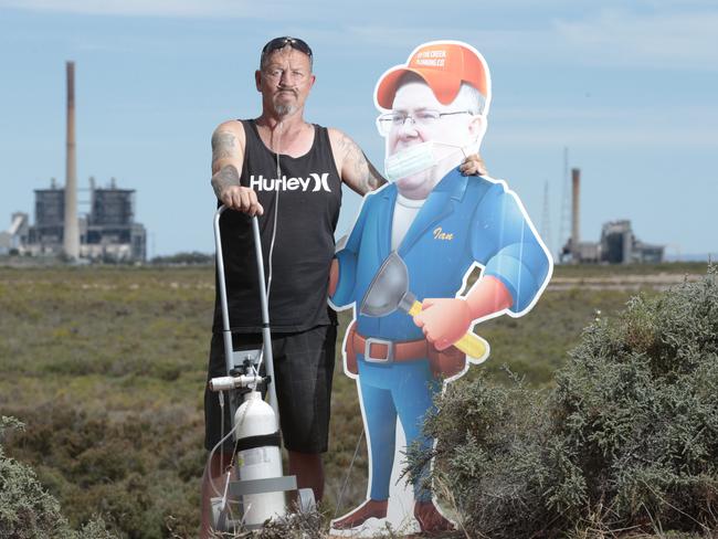 Garth Baker, 48, who lives within 2km of the defunct Northern Power Station at Port Augusta, with a cutout of Environment Minister Ian Hunter. Picture: Tait Schmaal.