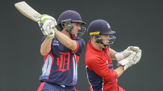 Dandenong batsman Tom Donnell cuts hard as Melbourne wicketkeeper Seb Gotch watches on.