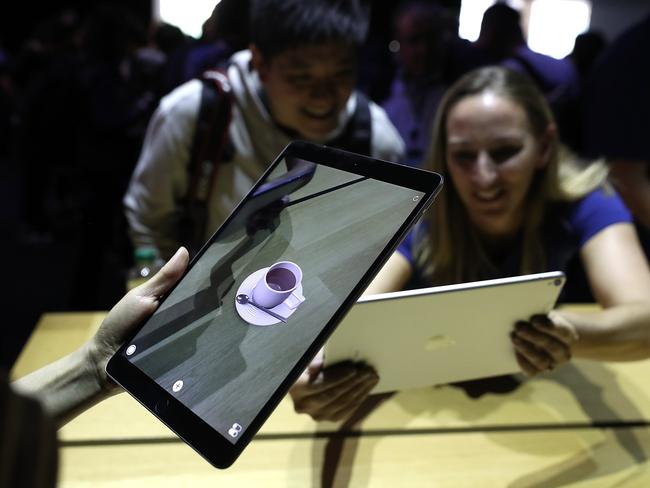 Invited journalists inspect the new iPad Pro 10.5 inch with the bezel clearly shrunk. Picture: Justin Sullivan