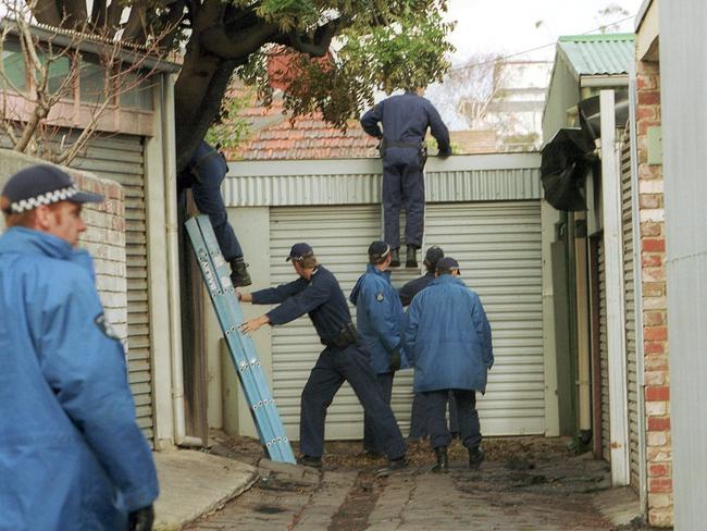 Investigators scour the area after a burnt-out Ford sedan — believed linked to the shooting — was found in Port Melbourne. Picture: HWT library