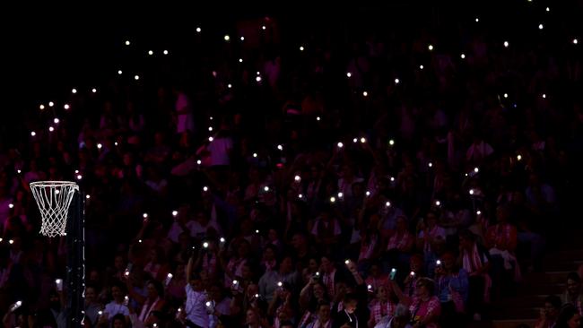 Fans hold torches during a power cut at Netball SA Stadium. Picture: Getty Images