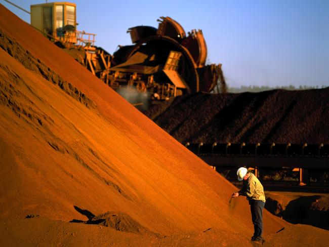 An undated handout photo made available 03 August 2005 shows a worker inspecting iron ore stockpiles at the outback location of Marandoo. Rio Tinto reports a record first-half net profit of 2.17 billion US dollars 03 August 2005. Rio Tinto posted the result, well ahead of market forecasts following a China-driven boom for resources and solid production figures. AFP PHOTO/RIO TINTO/HO (EDITORIAL USE ONLY)