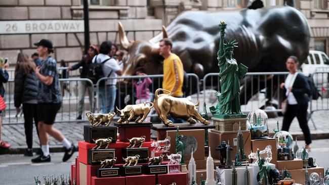 A vendor sells items near the Wall Street Bull beside the New York Stock Exchange. Picture: AFP