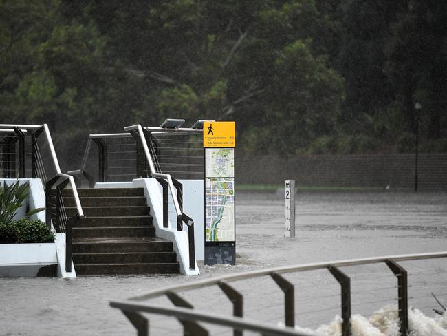 A footpath disappears as water overflows the banks of the Parramatta River after heavy rains in on Friday. Picture: AAP