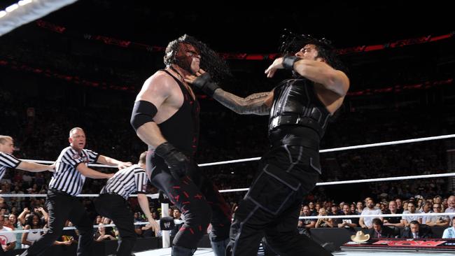 Roman Reigns (right) and Kane clash in a WWE match. Source: WWE