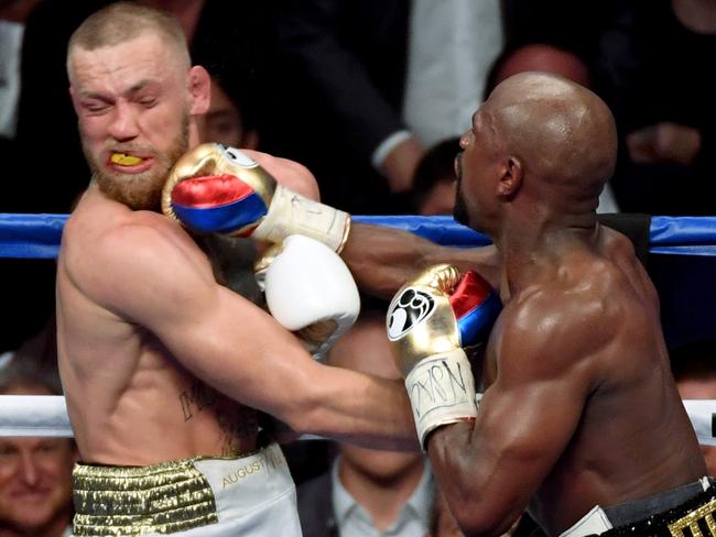 LAS VEGAS, NV - AUGUST 26: Floyd Mayweather Jr. (R) hits Conor McGregor with a right in the 10th round of their super welterweight boxing match at T-Mobile Arena on August 26, 2017 in Las Vegas, Nevada. Mayweather won by 10th-round TKO.   Ethan Miller/Getty Images/AFP == FOR NEWSPAPERS, INTERNET, TELCOS & TELEVISION USE ONLY ==