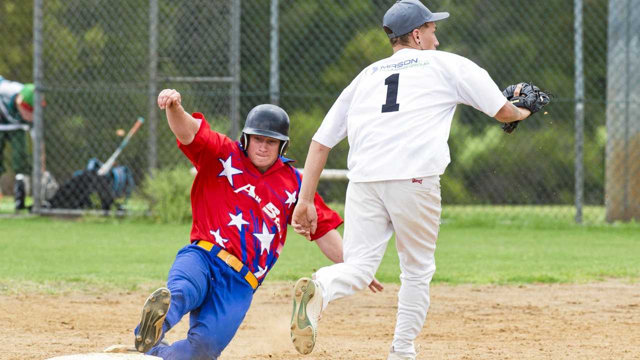 STATE DUTIES: Lewis Codd (left) slides safely into first base. Codd has been named in the Queensland Patriots team competing at the Australian championships. Picture: Nev Madsen