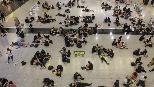 Protesters sit on the floor of the arrivals hall of Hong Kong's international airport. Picture: AFP