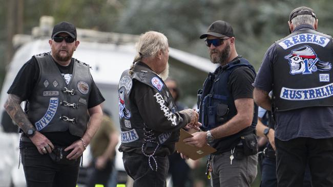 Police speak to some Rebels members on the roadside. Picture: Martin Ollman