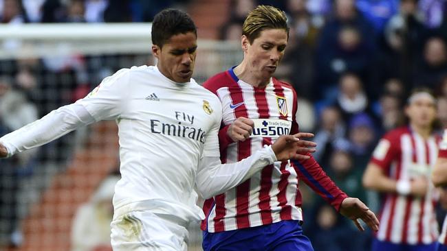Raphael Varane (L) and Atletico Madrid's forward Fernando Torres (R).
