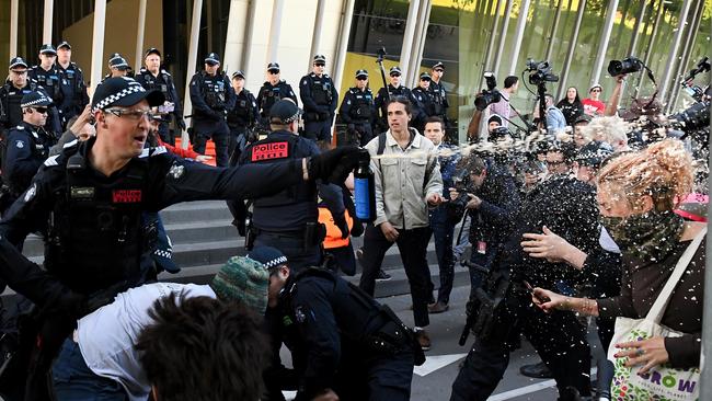 A Victoria Police officer uses pepper spray on environmental protesters outside the Melbourne Exhibition and Convention Centre in Melbourne.