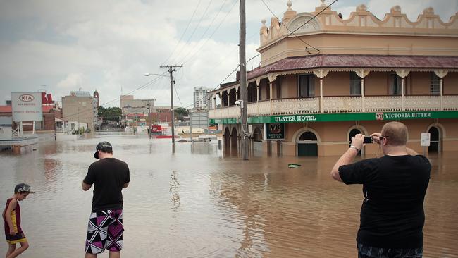 Tourists photograph the flooded Limestone Street in Central Ipswich. Picture-Patrick Hamilton