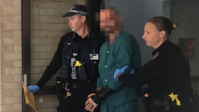 Police escort alleged Ben Hoffmann from Royal Darwin Hospital before charging him with four counts of murder in 2019. Picture: NTPFES