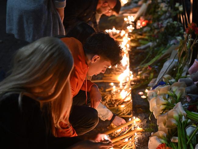 People light candles at a makeshift memorial for the victims following a shooting at a school in the Serbian capital Belgrade. (Photo by ANDREJ ISAKOVIC / AFP)