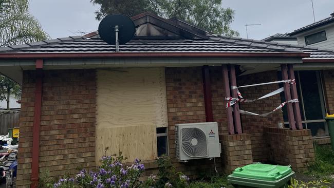 The front windows have been boarded up and rubbish could be seen along the side of the house.