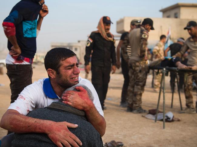 Father and grandfather of 15-year-old Shafiq mourn as Iraqi forces surround his body at an outdoor field clinic in the Samah neighbourhood in Mosul on November 13, 2016. Picture: / AFP PHOTO / Odd ANDERSEN