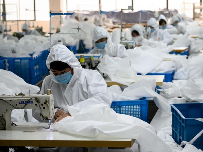 Workers sewing at factory making hazardous material suits to be used in the COVID-19 coronavirus outbreak, at the Zhejiang Ugly Duck Industry garment factory in Wenzhou.