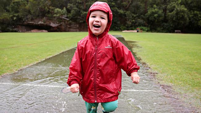 Otto Grenville, 3, playing in puddles during today's wet weather in Cammeray. Picture: Adam Yip