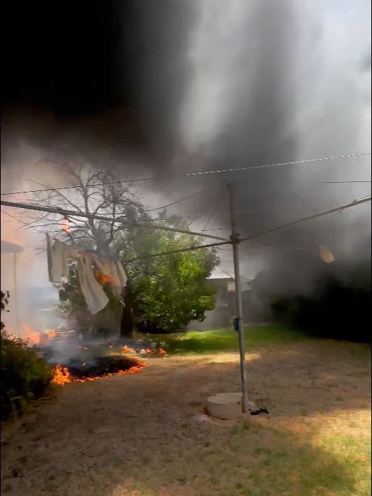 Hero tradies jumped the fence after they drove past the fire on their lunch break. Picture: 7NEWS