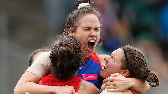 MELBOURNE, AUSTRALIA - MARCH 24: Emma Kearney of the Bulldogs (second from left) celebrates a goal with teammates L-R Ellie Blackburn, and Kirsty Lamb during the 2018 AFLW Grand Final match between the Western Bulldogs and the Brisbane Lions at IKON Park on March 24, 2018 in Melbourne, Australia. (Photo by Adam Trafford/AFL Media/Getty Images)