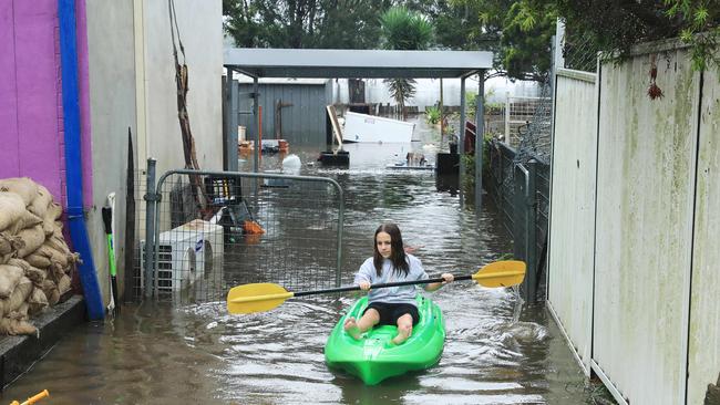 Chloe Panman, 13, uses a kayak to check on her pet rabbit. Picture: John Feder