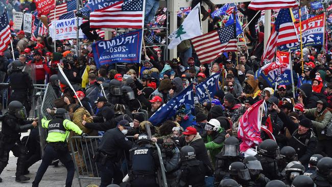 In this file photo taken on January 06, 2021 Trump supporters clash with police and security forces as they push barricades to storm the US Capitol in Washington D.C.