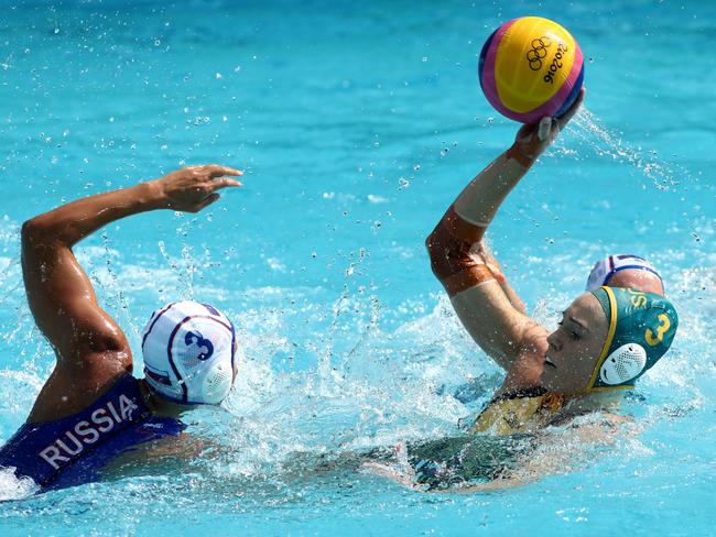 Buckling passes over Ekaterina Prokofyeva of Russia during the preliminary round, group A women’s water polo match between Russia and Australia on day four of the Rio Olympics in the Maria Lenk Aquatics Centre on August 9. Picture: Phil Walter/Getty Images