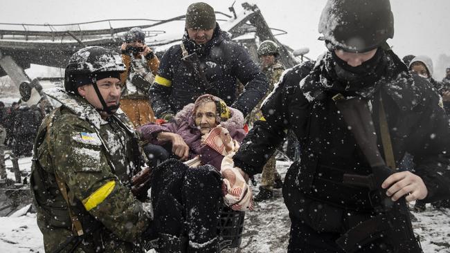 Officers evacuate an elderly woman as civilians continue to flee from Irpin due to ongoing Russian attacks. Picture: Emin Sansar/Anadolu Agency via Getty Images