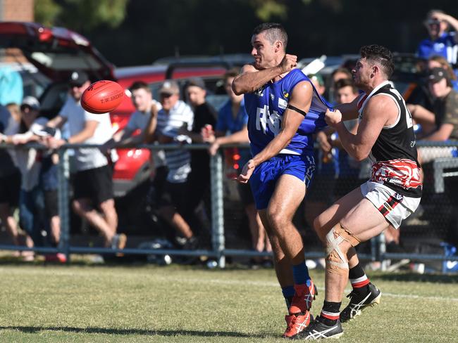 Hastings player Luke Hewitt gets a handball away as he’s tackled.