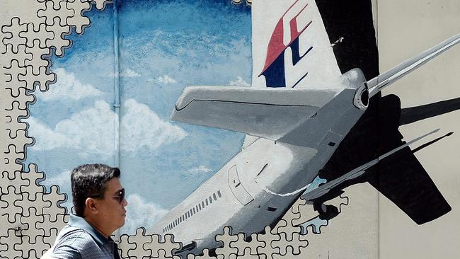 A man walks past a mural of missing Malaysia Airlines MH370 in Shah Alam. 