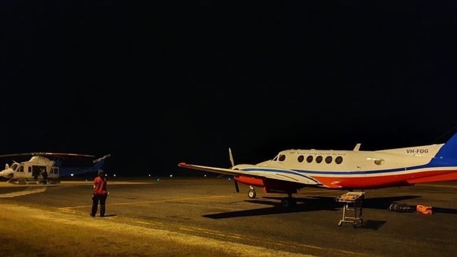 Two men mauled by a saltwater croc were transferred from a rescue helicopter to a Royal Flying Doctor Service of Australia plane at the Lockhart River airstrip on Friday night. Picture: RFDS