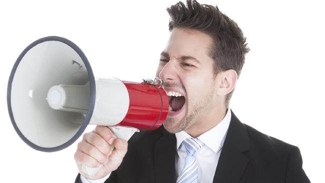 Full length of young businessman screaming into megaphone over white background