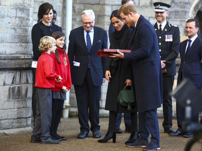 Harry Smith and Megan Taylor, both from Marlborough Primary School, present a wedding gift to Britain’s Prince Harry and his fiancée Meghan Markle on their arrival at Cardiff Castle in Cardiff, south Wales on January 18, 2018, for a day showcasing the rich culture and heritage of Wales. Picture: AFP