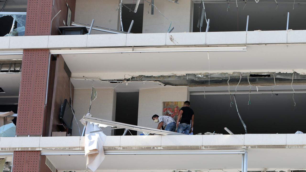 People inspect the damage on buildings near the port. Picture: AFP