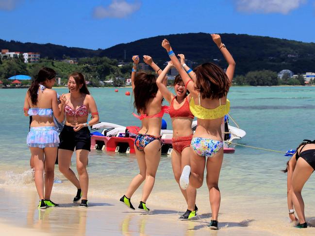 Tourists enjoy the activities along Tumon beach on the island of Guam on August 11, 2017. Tourism-dependent Guam is looking to cash in on its new-found fame as a North Korean missile target, tapping an unlikely promotional opportunity to attract visitors to the idyllic island and prove that all publicity is good publicity. / AFP PHOTO / Virgilio VALENCIA