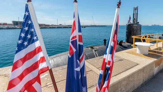 National flags of the USA, Australia and Great Britain are seen in front of the USS Asheville, a Los Angeles-class nuclear powered fast attack submarine, at HMAS Stirling, Western Australia on Tuesday, March 14, 2023. Picture: NCA NewsWire / pool / Richard Wainwright