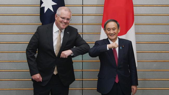 Australia's Prime Minister Scott Morrison (L) and Japan's Prime Minister Yoshihide Suga (R) bump elbows as they pose at the start of their bilateral meeting at Suga's official residence in Tokyo.