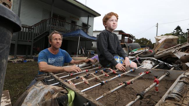 Flood clean up at Tweed River Towns. John Lawrence and son Balin Lawrence mourn the loss of their soccer table during clean up in Condong. Picture Glenn Hampson