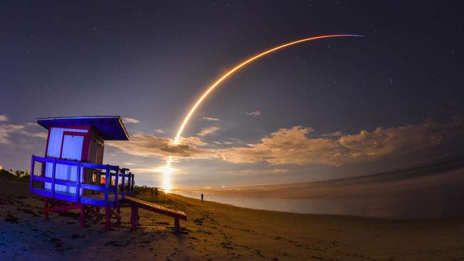 The launch of Telesat's Telstar 18 Vantage communications satellite on a SpaceX Falcon 9 rocket, launched from Launch Complex 40 at Cape Canaveral Air Force Station, is viewed from Minutemen Causeway in Cocoa Beach, early Monday, Sept. 10, 2018. Photo is a 145-second time exposure of the launch with life guard station in the foreground. (Malcolm Denemark/Florida Today via AP)